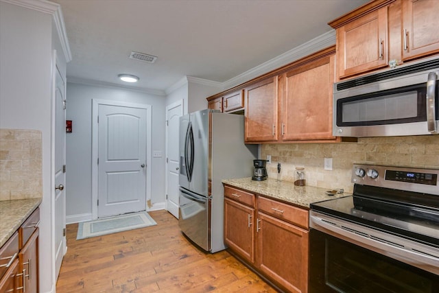 kitchen featuring light wood-type flooring, stainless steel appliances, decorative backsplash, and light stone countertops