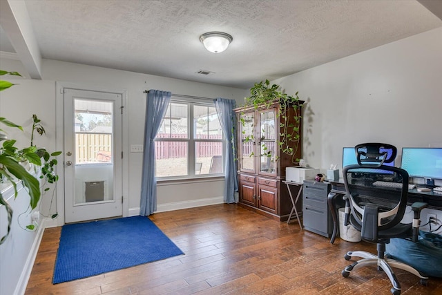 office area with dark hardwood / wood-style floors and a textured ceiling