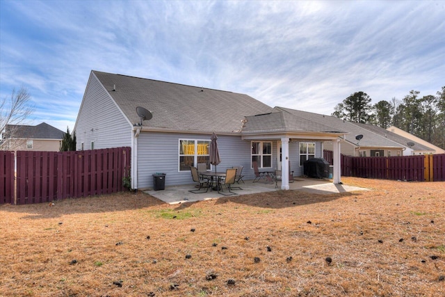 rear view of property featuring a patio area and a lawn