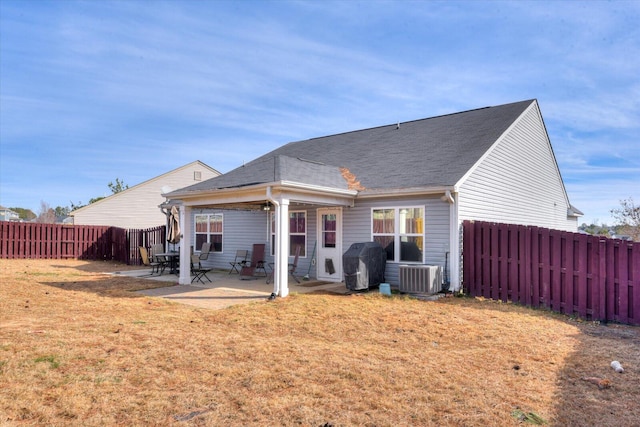 back of property with central AC unit, a patio, and a yard