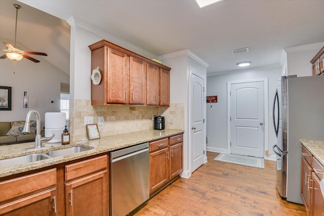 kitchen with ceiling fan, backsplash, sink, light wood-type flooring, and appliances with stainless steel finishes