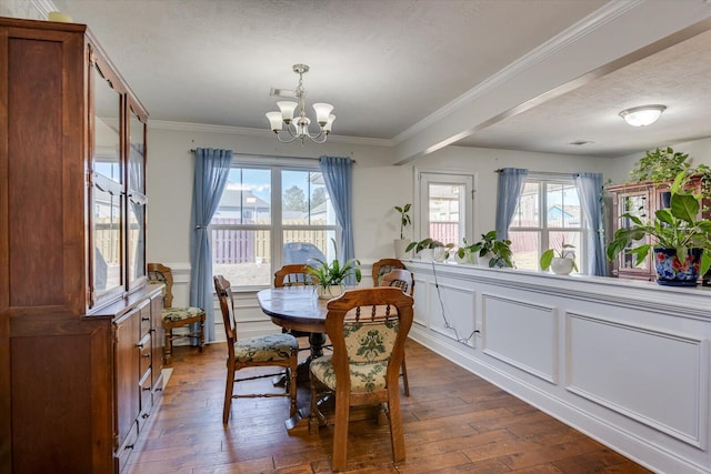 dining area featuring dark hardwood / wood-style floors, crown molding, a textured ceiling, and a notable chandelier