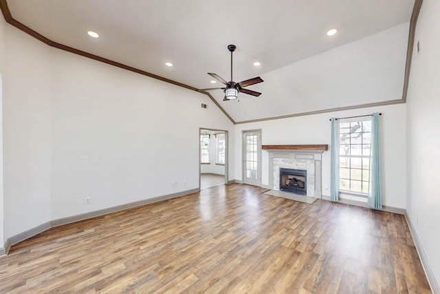 unfurnished living room with light wood-type flooring, lofted ceiling, crown molding, and ceiling fan