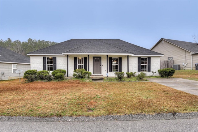 ranch-style home with cooling unit and a front lawn