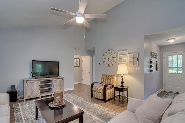 living room with wood-type flooring, ceiling fan, and high vaulted ceiling