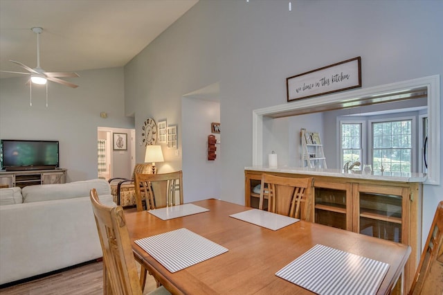 dining room featuring ceiling fan, vaulted ceiling, and light hardwood / wood-style flooring