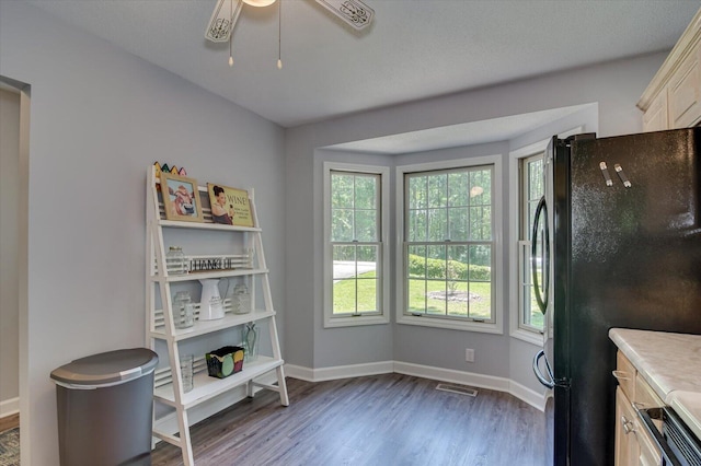 kitchen with black fridge, dark hardwood / wood-style floors, and ceiling fan