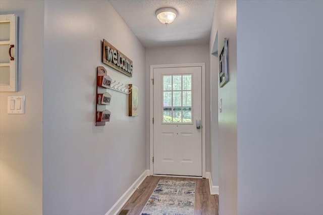 doorway featuring dark wood-type flooring and a textured ceiling