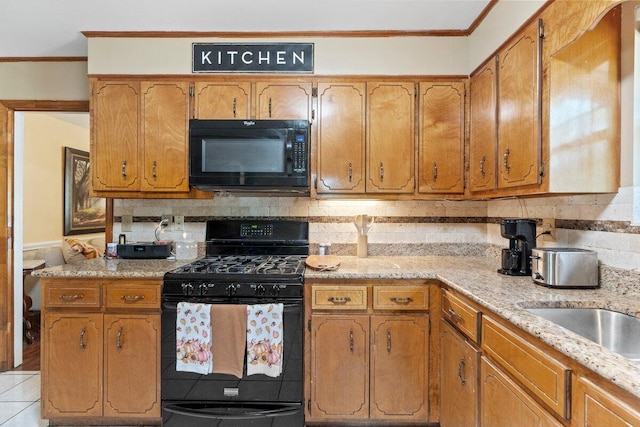 kitchen with light stone counters, backsplash, light tile patterned floors, black appliances, and ornamental molding