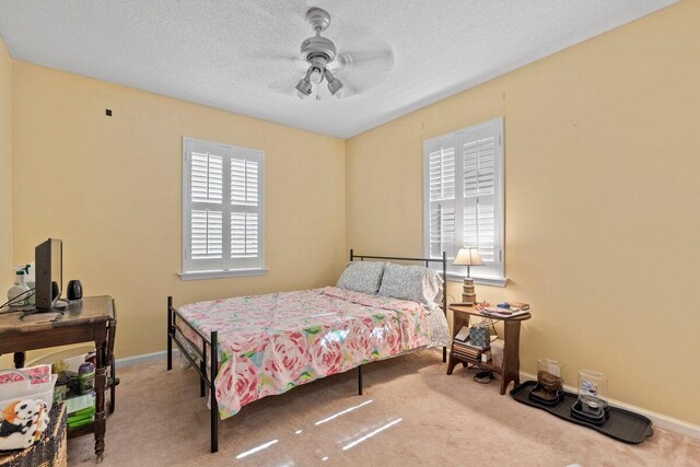 bedroom featuring carpet, ceiling fan, and a textured ceiling