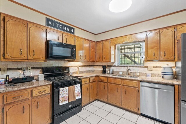 kitchen with sink, backsplash, crown molding, light tile patterned floors, and black appliances