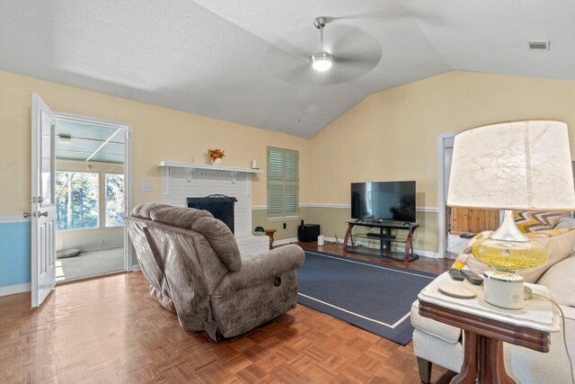 living room featuring a fireplace, ceiling fan, lofted ceiling, and parquet flooring