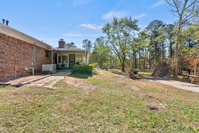 view of yard with central AC unit and a porch