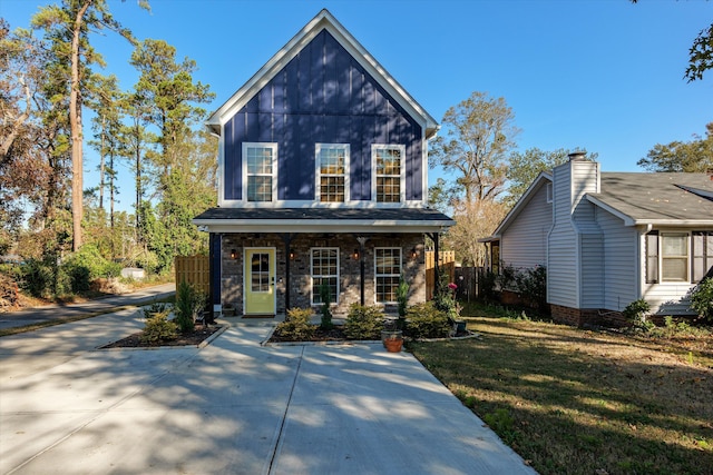 view of property featuring covered porch and a front yard