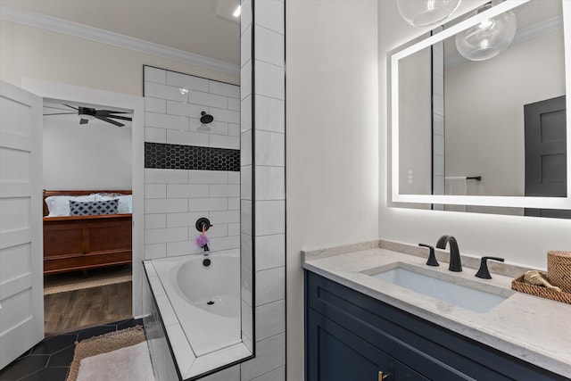 bathroom featuring tiled shower / bath, vanity, ceiling fan, crown molding, and tile patterned floors