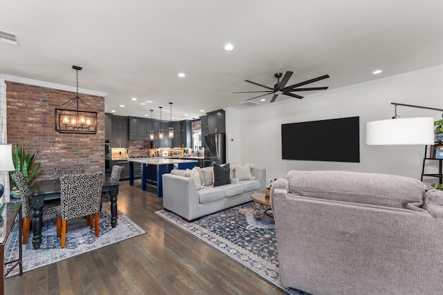 living room featuring crown molding, dark hardwood / wood-style floors, and ceiling fan with notable chandelier