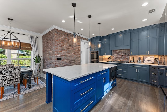 kitchen with decorative light fixtures, dark hardwood / wood-style flooring, a center island, stainless steel appliances, and blue cabinetry