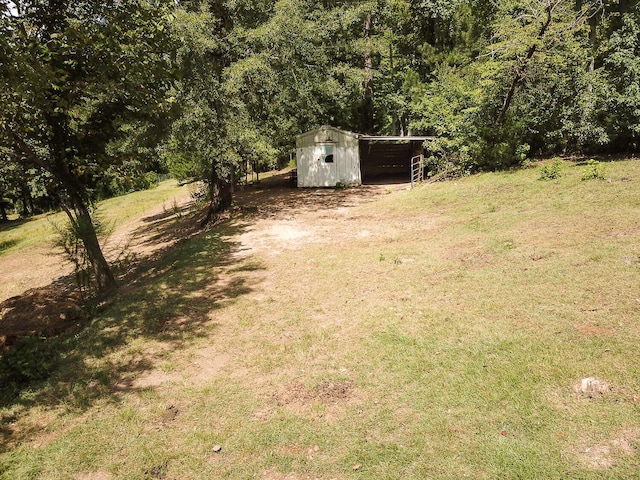 2700 Summit Ridge Rd, Evans, GA 30809 - view of green lawn featuring a carport, a storage shed, and a forest view