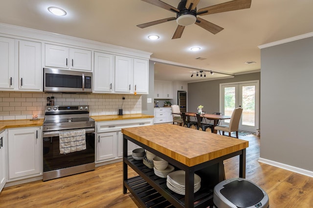 2700 Summit Ridge Rd, Evans, GA 30809 - kitchen with appliances with stainless steel finishes, butcher block countertops, ornamental molding, white cabinetry, and backsplash