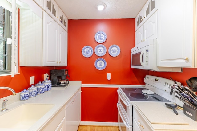 2161 Chadwick Rd, Augusta, GA 30906 - kitchen featuring white appliances, light countertops, white cabinetry, glass insert cabinets, and a textured ceiling