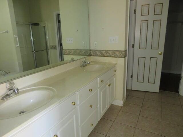 bathroom with vanity, a shower with door, and tile patterned floors