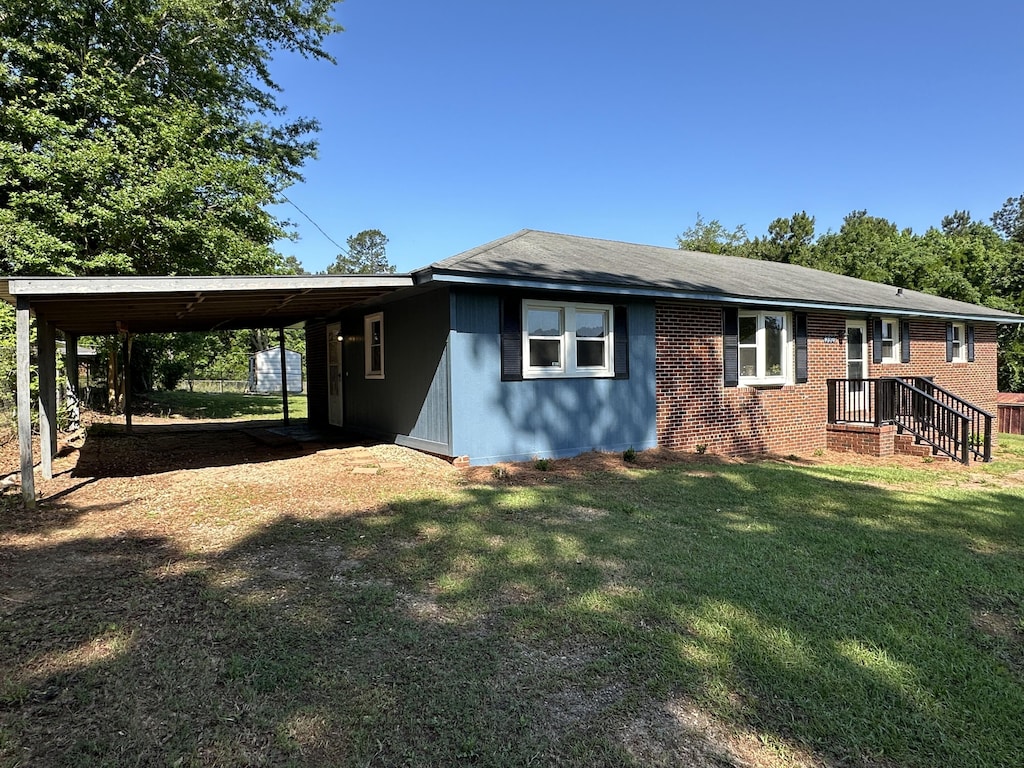 view of front of property featuring a front lawn and a carport