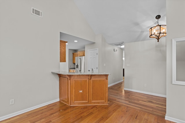 603 Ridgefield Dr, North Augusta, SC 29841 - kitchen with stainless steel fridge, light wood-type flooring, a peninsula, brown cabinets, and a chandelier