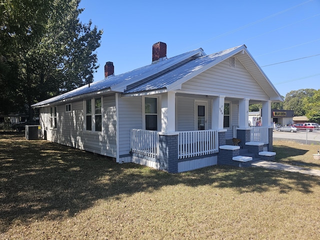 view of front of home featuring covered porch, central AC, and a front yard