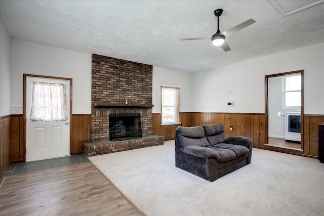 living room featuring wooden walls, wainscoting, and a wealth of natural light