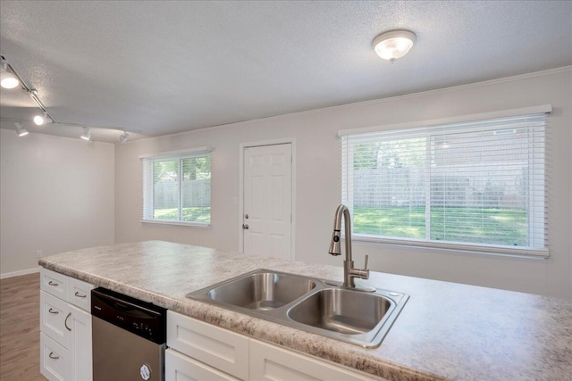 kitchen featuring white cabinets, a textured ceiling, a sink, and dishwasher