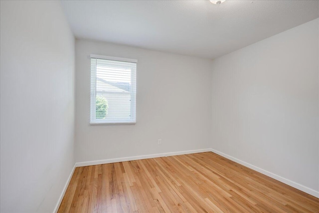 spare room with light wood-type flooring and baseboards