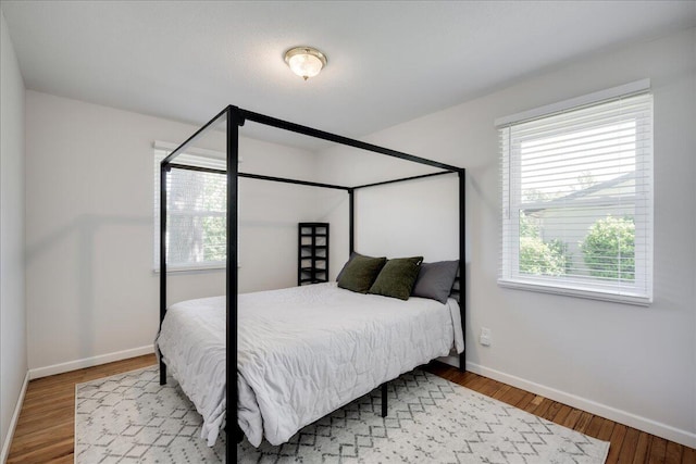 bedroom featuring baseboards and wood finished floors