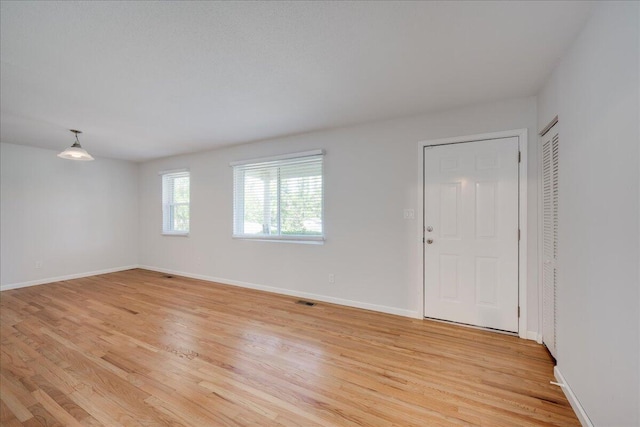 interior space featuring baseboards, light wood-style flooring, and visible vents