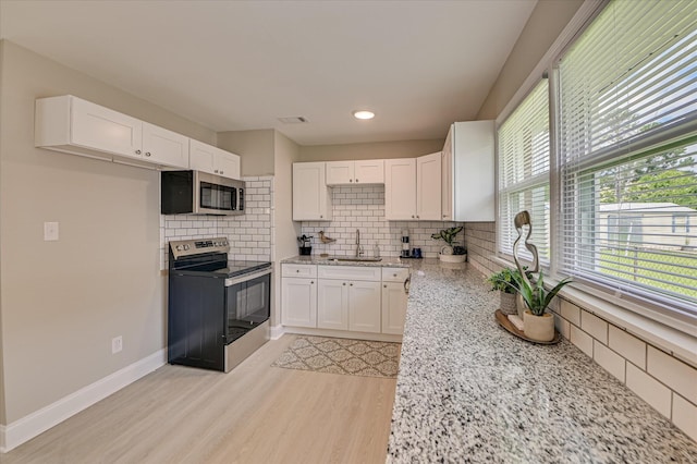 415 Aiken St, Augusta, GA 30901 - kitchen with stainless steel appliances, a sink, white cabinetry, light stone counters, and tasteful backsplash