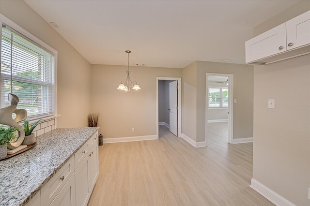 415 Aiken St, Augusta, GA 30901 - kitchen with light wood-style floors, a chandelier, white cabinetry, and light stone counters
