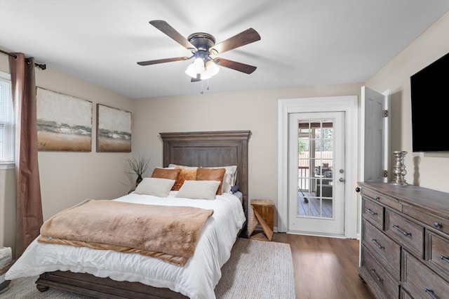 bedroom with dark wood finished floors, access to outside, and ceiling fan