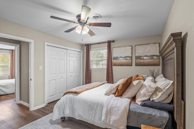 bedroom featuring wood finished floors, a closet, baseboards, and multiple windows