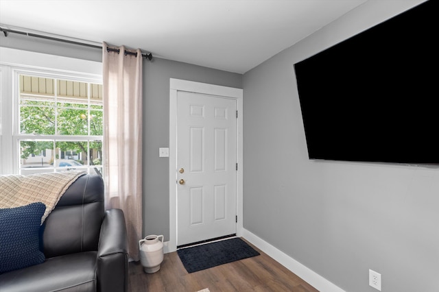 foyer entrance featuring dark wood finished floors and baseboards