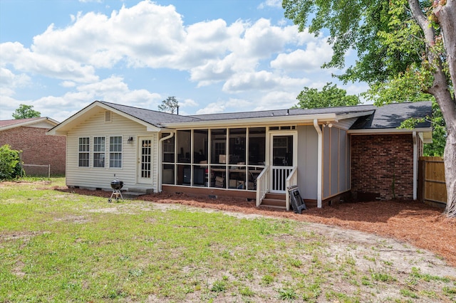 rear view of property featuring a yard, fence, entry steps, a sunroom, and crawl space