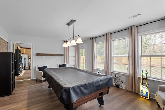 recreation room with dark wood-type flooring, visible vents, and a healthy amount of sunlight
