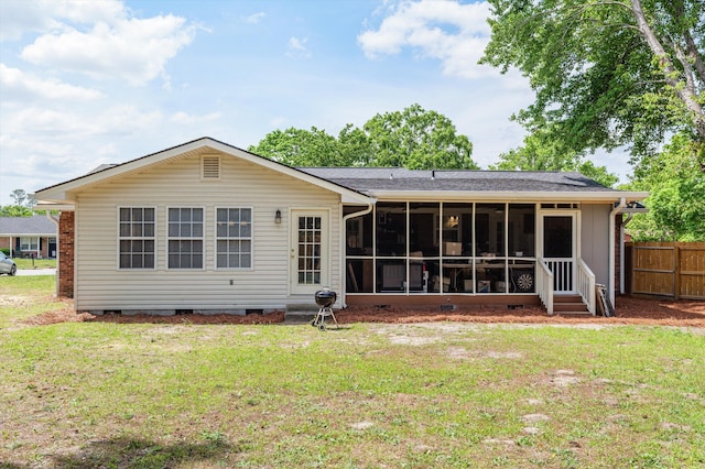 back of property with fence, a lawn, crawl space, and a sunroom