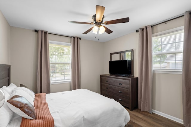 bedroom featuring baseboards, wood finished floors, and ceiling fan