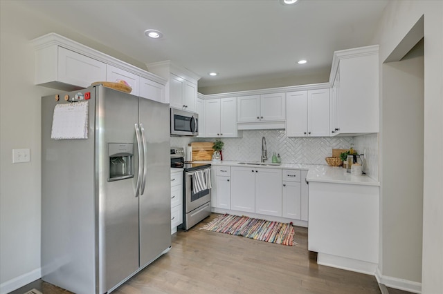 1745 Oak Dr, Augusta, GA 30904 - kitchen featuring appliances with stainless steel finishes, backsplash, white cabinetry, light countertops, and light wood-style floors