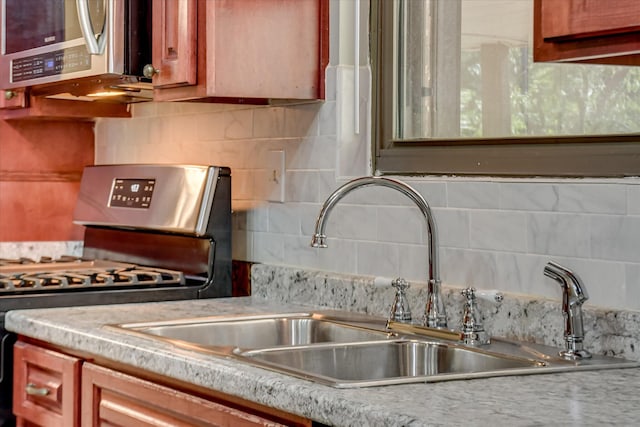 3515 Potomac Dr, Augusta, GA 30906 - kitchen featuring appliances with stainless steel finishes, tasteful backsplash, a sink, light countertops, and brown cabinetry