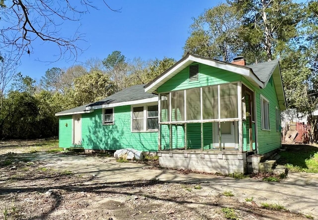 view of property exterior with a sunroom