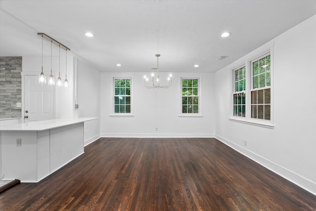 unfurnished dining area featuring a chandelier and dark wood-type flooring