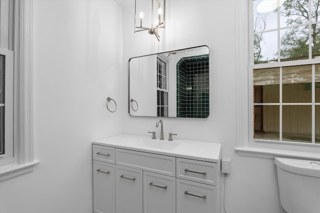 bathroom featuring a chandelier, vanity, and toilet