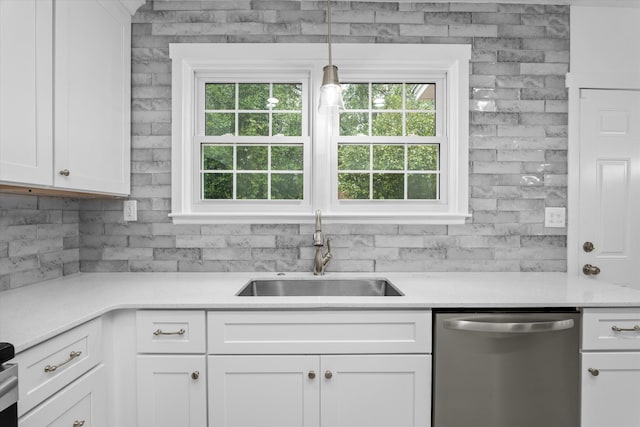 kitchen featuring pendant lighting, white cabinetry, sink, and stainless steel dishwasher