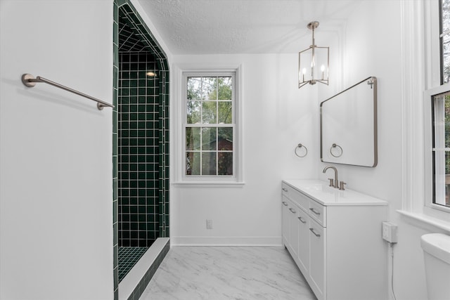 bathroom featuring a textured ceiling, vanity, tiled shower, a notable chandelier, and toilet