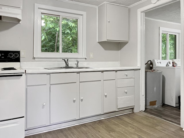 kitchen with white range with electric cooktop, under cabinet range hood, a sink, healthy amount of natural light, and ornamental molding